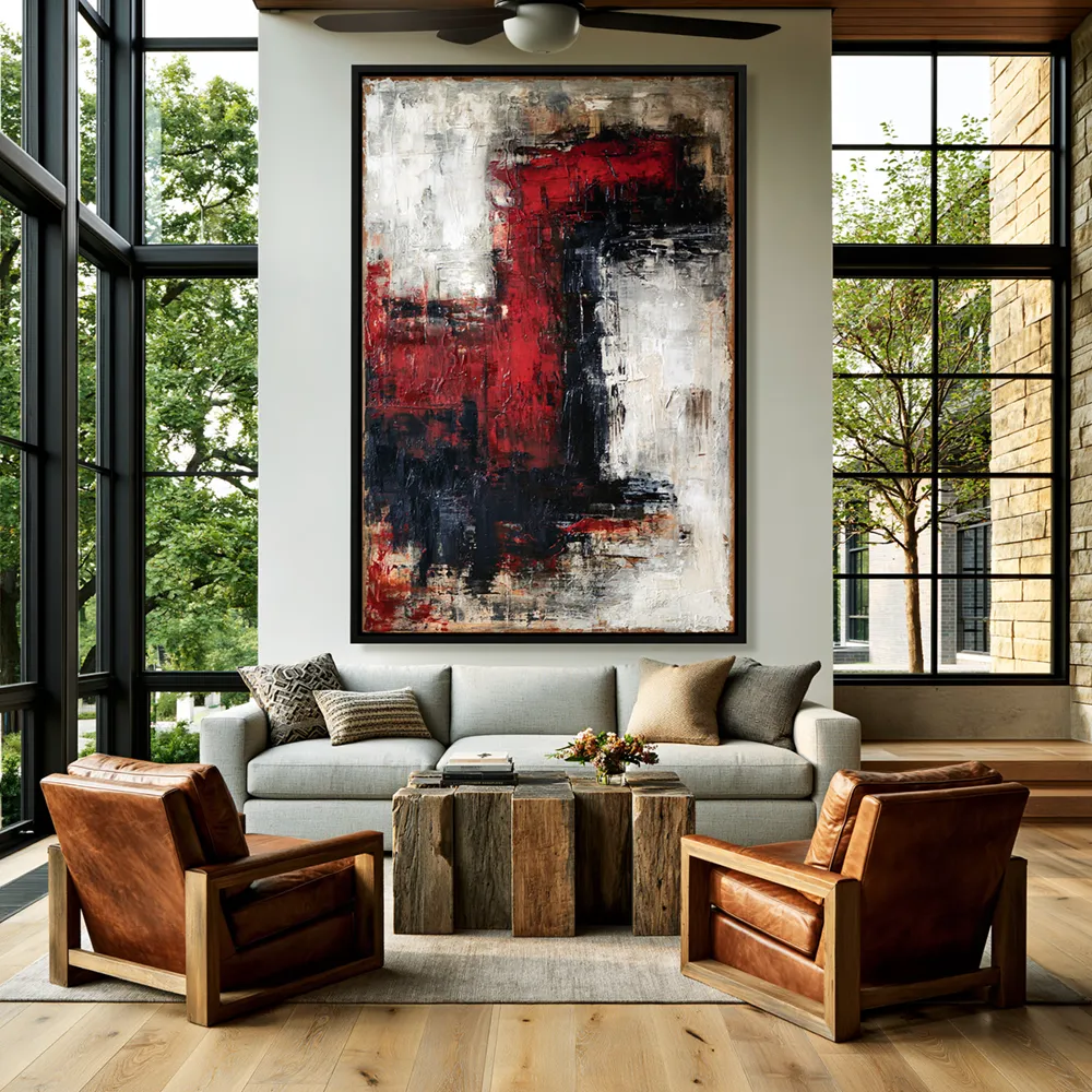 Modern living room with red, black, and white abstract wall art above a light gray sofa and brown leather chairs